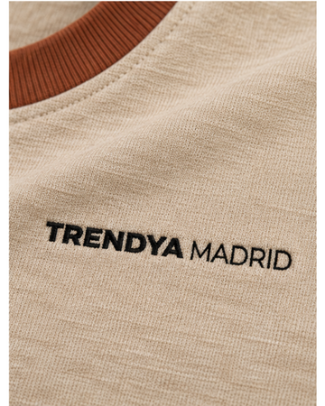 Detalle del cuello de canalé terracota y del logotipo Trendya Madrid bordado en el pecho