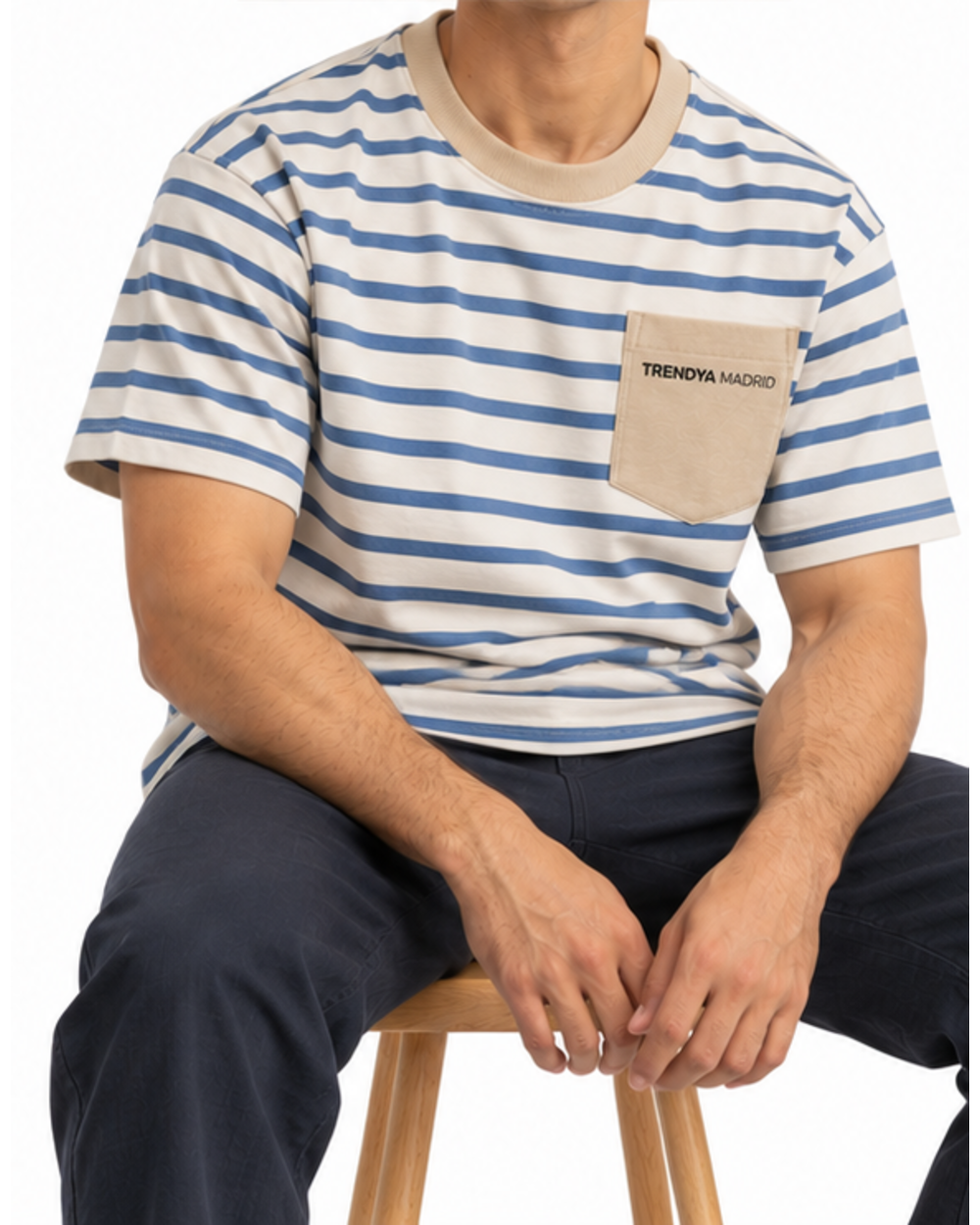 Camiseta de rayas de hombre crudo y azul con bolsillo arena puesta, modelo sentado en un taburete