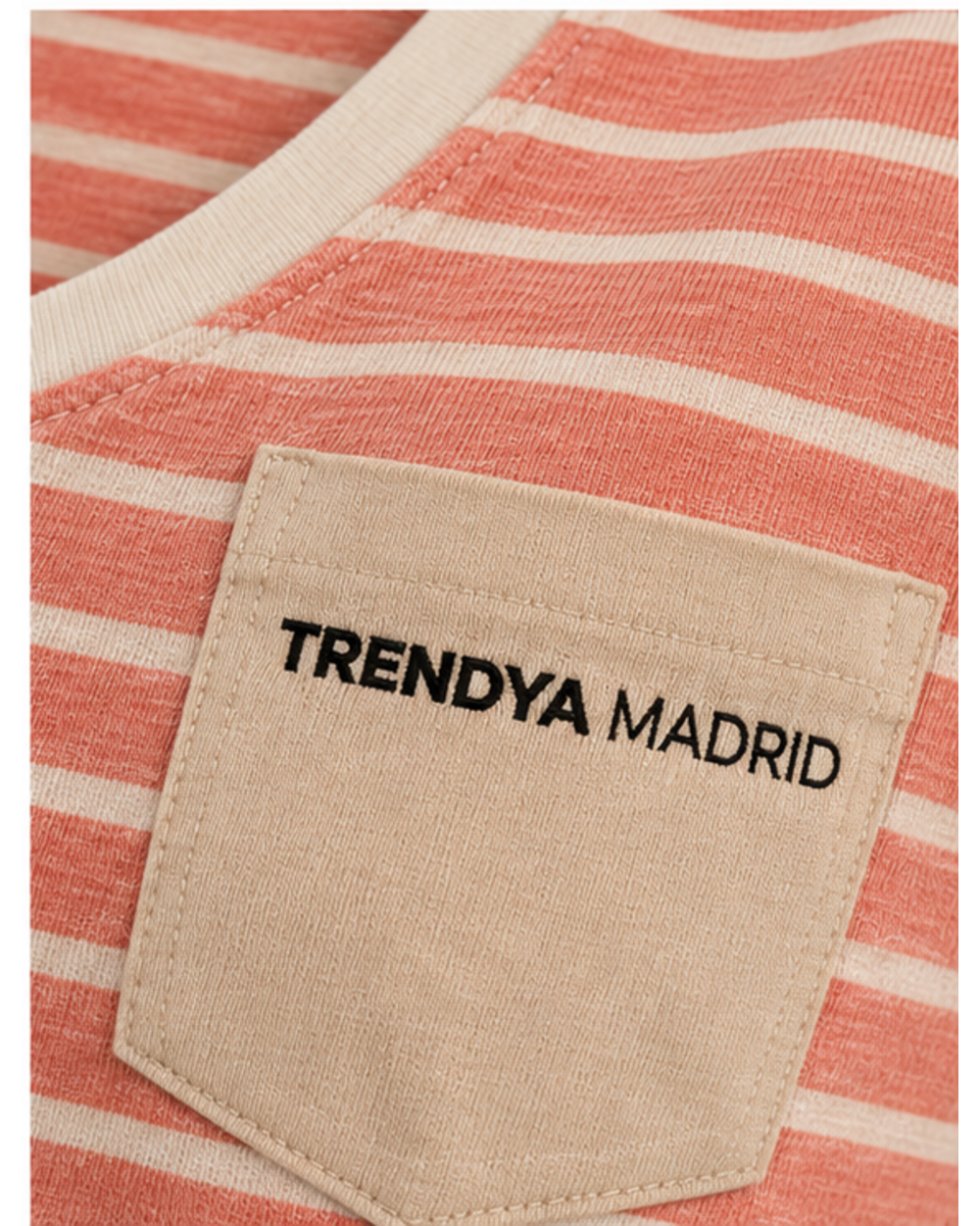Detalle del bolsillo color arena con el logotipo Trendya Madrid bordado sobre las rayas coral