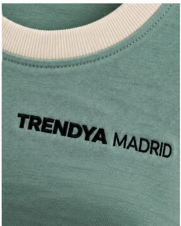 Detalle del cuello con ribete marfil y del logotipo Trendya Madrid bordado sobre el verde agua