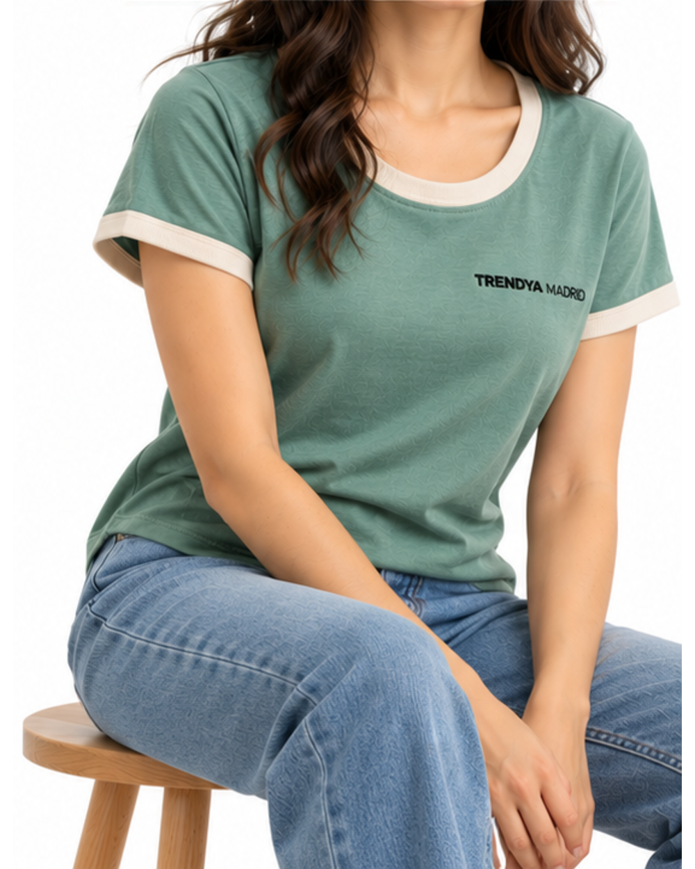 Camiseta de mujer verde agua con ribetes marfil puesta, modelo sentada en un taburete